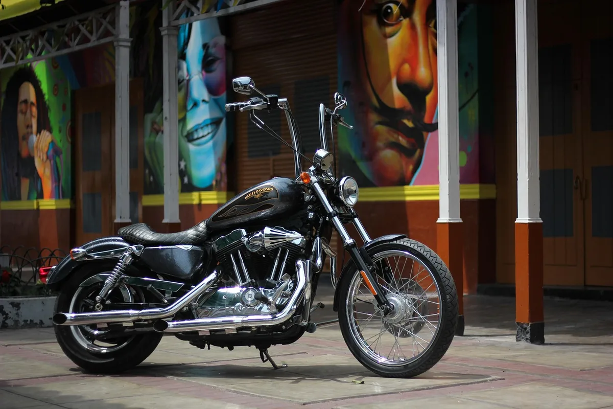Inside a motorcycle workshop with a custom bike frame on a lift and tools on a bench