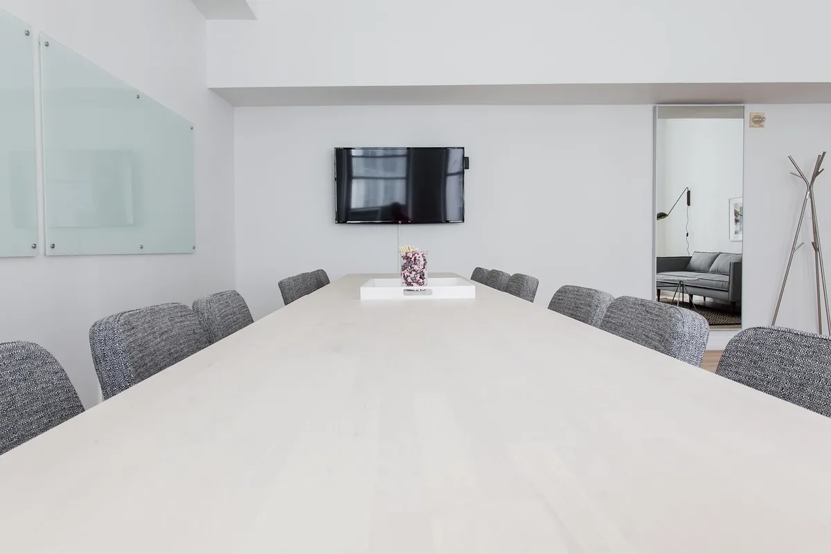 Producers and executives in a TV studio meeting discussing a joint production