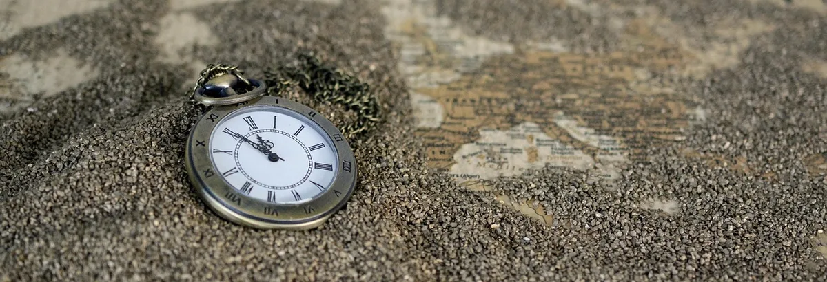 Hands on a typewritten script beside a vintage pocket watch on a production table