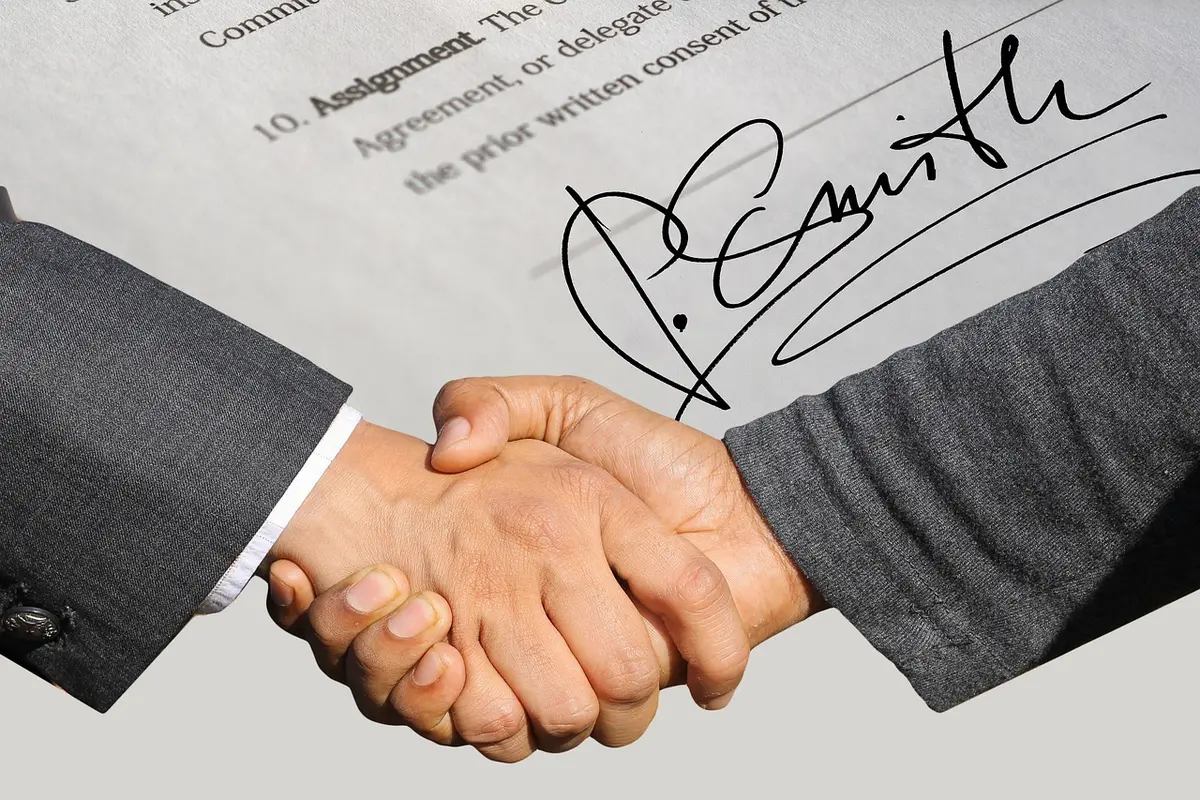 Hands with film canisters and a contract on a production office table