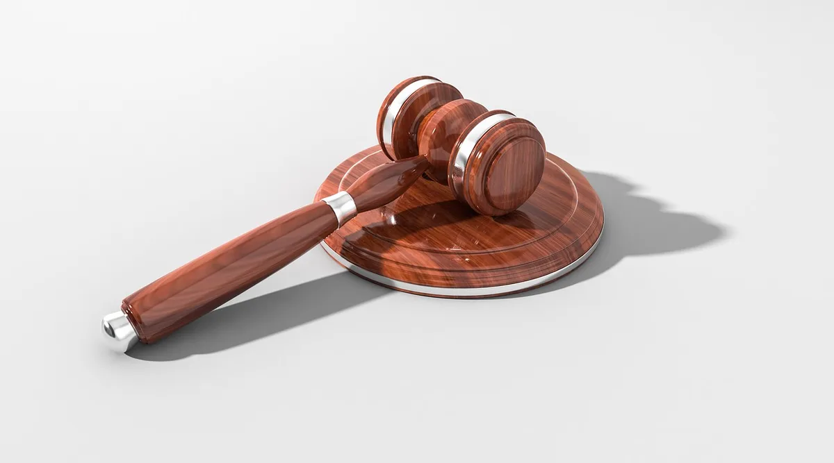 Gavel and signed merger documents on a desk symbolizing approval of a corporate deal